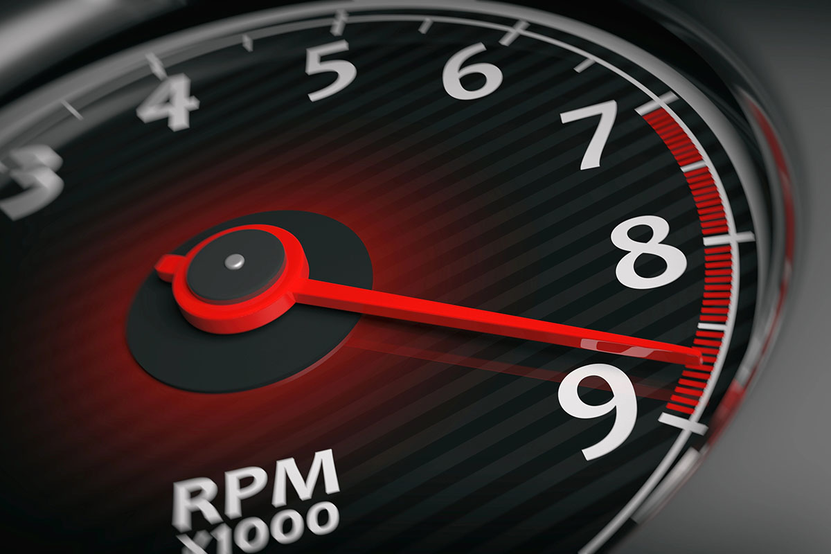 Close-up of a tachometer displaying RPM, with the needle pointing near 9,000 RPM, featuring a black background and bold white markings.