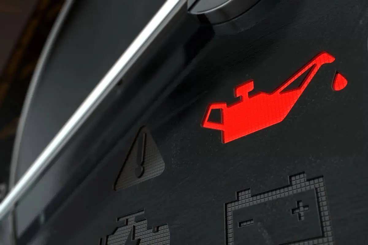Close-up of a dashboard with the check oil light is on.